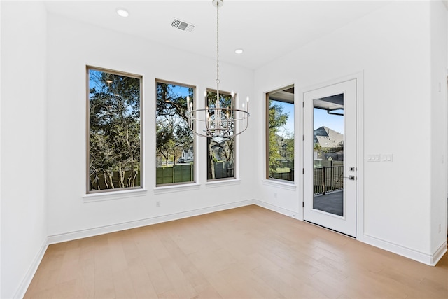 unfurnished dining area with light hardwood / wood-style flooring and an inviting chandelier