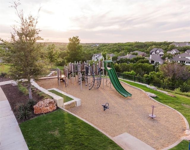 playground at dusk featuring a lawn