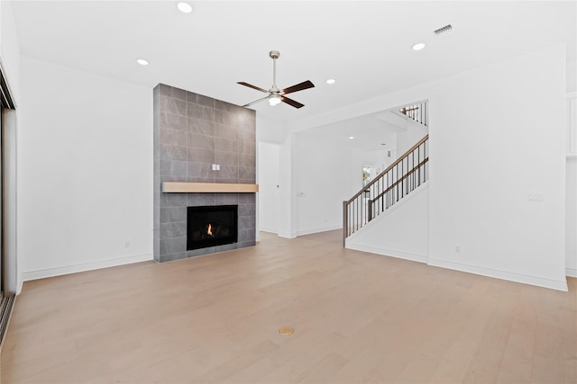 unfurnished living room with a fireplace, light hardwood / wood-style flooring, and ceiling fan