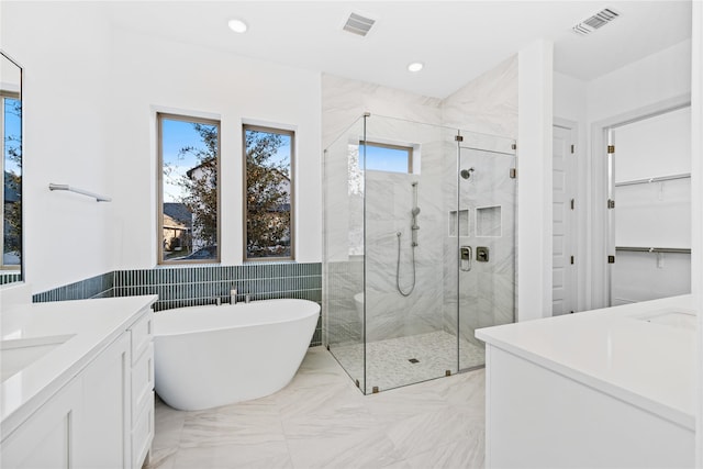 bathroom featuring tile walls, vanity, and shower with separate bathtub