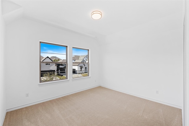 unfurnished room with carpet flooring and vaulted ceiling