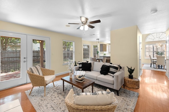 living room with ceiling fan, light hardwood / wood-style floors, and french doors