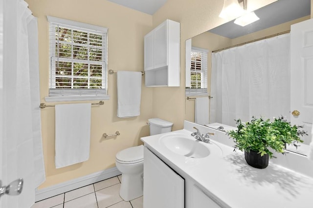 bathroom with toilet, vanity, and tile patterned floors