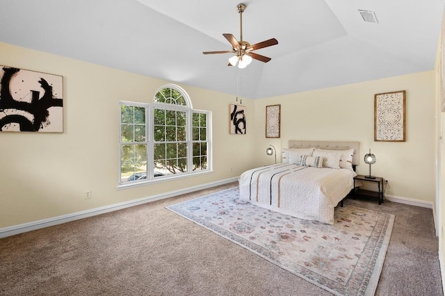 bedroom with carpet flooring, a tray ceiling, vaulted ceiling, and ceiling fan