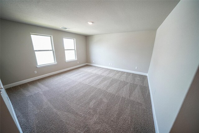 empty room with carpet flooring and a textured ceiling