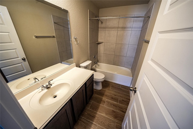 full bathroom with vanity, tiled shower / bath combo, and toilet