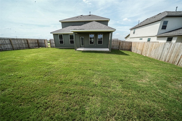 back of house with a yard and a patio