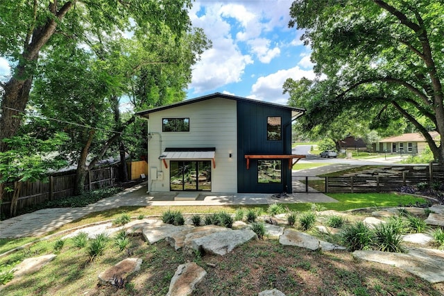 rear view of property featuring fence