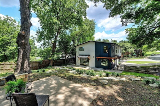 rear view of property with a patio and a fenced backyard