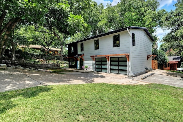 view of front of house with a garage, concrete driveway, and a front yard