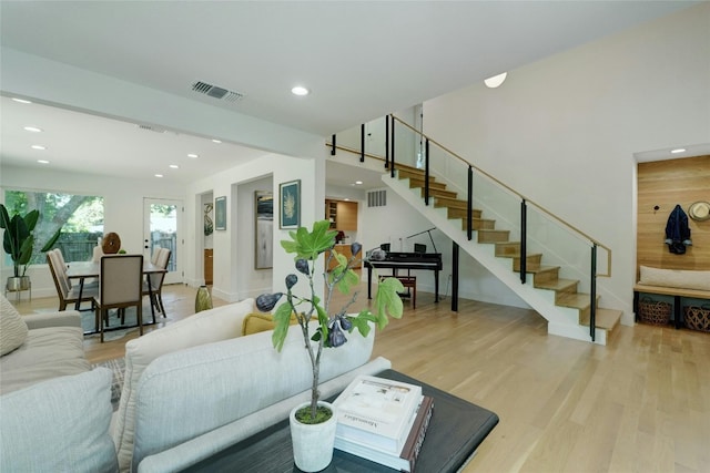 living room featuring stairs, recessed lighting, visible vents, and light wood-style floors