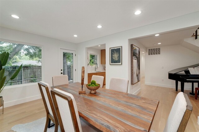 dining space with light wood-type flooring and sink