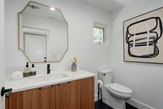 3104 Santa Monica Dr, Austin, TX 78741 - half bathroom featuring vanity, toilet, and baseboards