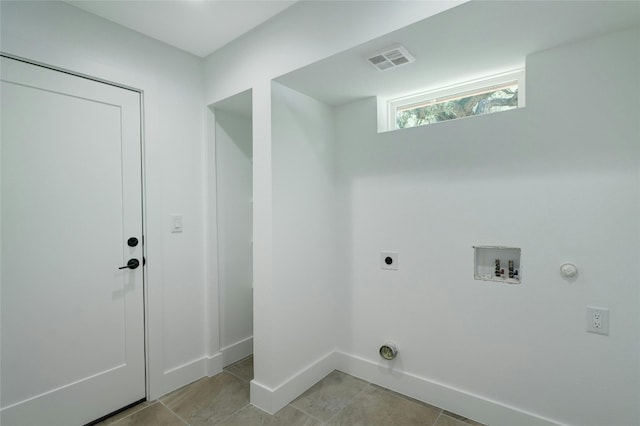 3104 Santa Monica Dr, Austin, TX 78741 - laundry area featuring hookup for an electric dryer, washer hookup, hookup for a gas dryer, light tile patterned floors, and baseboards