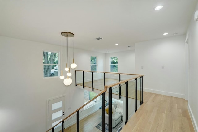 interior space featuring visible vents, plenty of natural light, baseboards, and wood finished floors