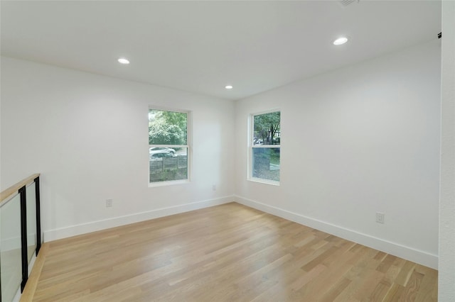 unfurnished room featuring light wood-type flooring, baseboards, and recessed lighting