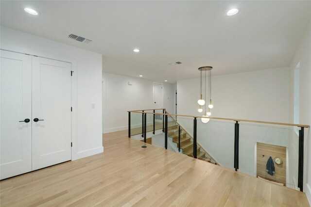 3104 Santa Monica Dr, Austin, TX 78741 - hall with an upstairs landing, wood finished floors, recessed lighting, and baseboards