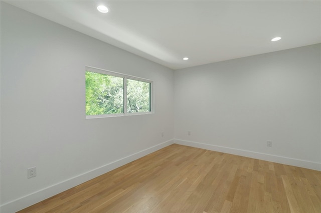 empty room with recessed lighting, light wood-style flooring, and baseboards