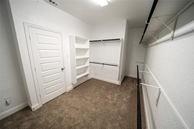 spacious closet with dark colored carpet and visible vents