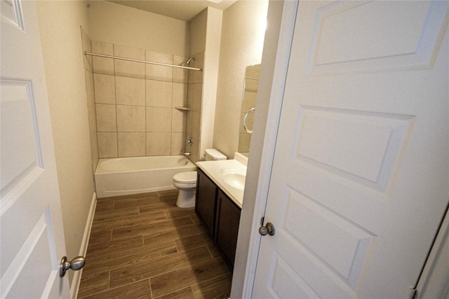 bathroom featuring toilet, wood tiled floor, bathing tub / shower combination, and vanity