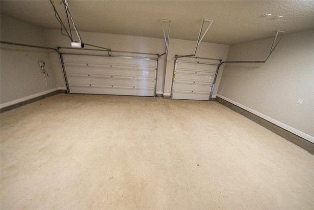 garage featuring a garage door opener and baseboards