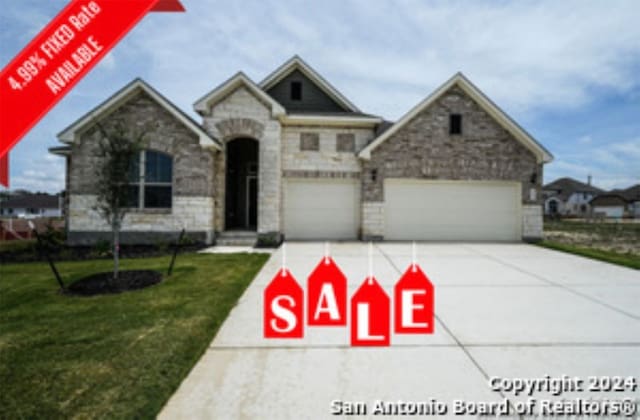 213 Fillmore Fls, Cibolo, TX 78108 - view of front of house with concrete driveway, a front yard, stone siding, and a garage