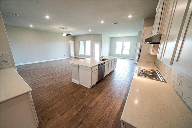 kitchen with visible vents, dark wood finished floors, dishwasher, under cabinet range hood, and a sink