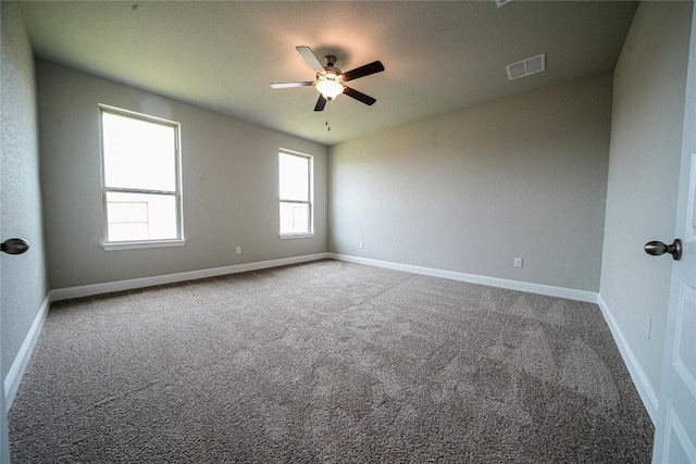 unfurnished room featuring a ceiling fan, carpet, visible vents, and baseboards