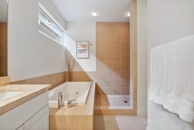 bathroom with vanity, a tub with jets, and tile patterned floors