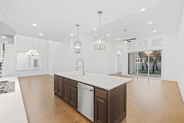 kitchen featuring stainless steel dishwasher, ceiling fan, sink, decorative light fixtures, and light hardwood / wood-style flooring