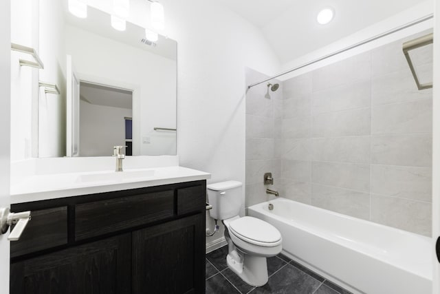 full bathroom featuring tile patterned floors, vaulted ceiling, toilet, vanity, and tiled shower / bath