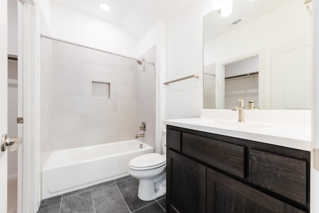 full bathroom featuring tiled shower / bath combo, toilet, lofted ceiling, and vanity