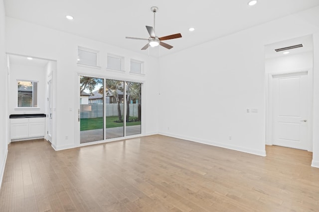 unfurnished living room featuring ceiling fan, plenty of natural light, and light hardwood / wood-style floors