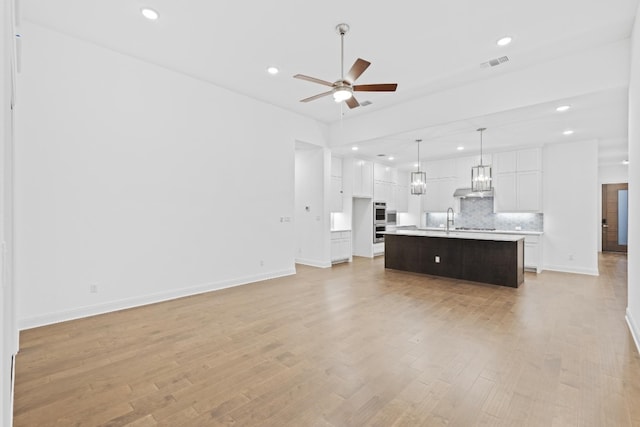 unfurnished living room featuring ceiling fan, sink, and light hardwood / wood-style floors