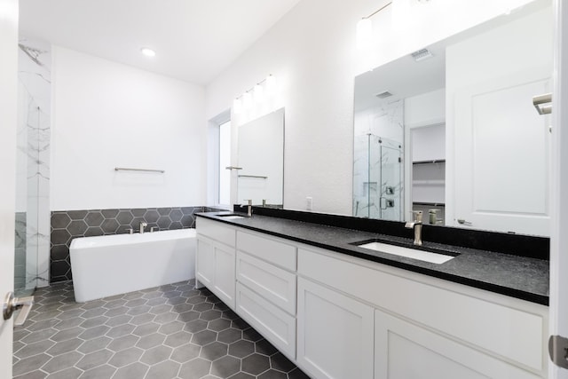 bathroom with tile patterned floors, vanity, plus walk in shower, and tile walls