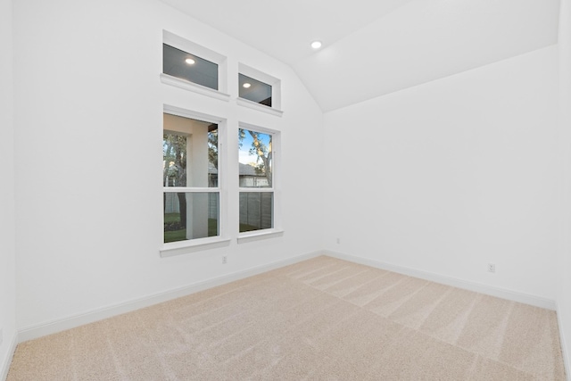 unfurnished room with carpet flooring and vaulted ceiling