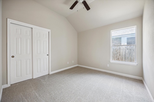 unfurnished bedroom with carpet, a closet, vaulted ceiling, and ceiling fan