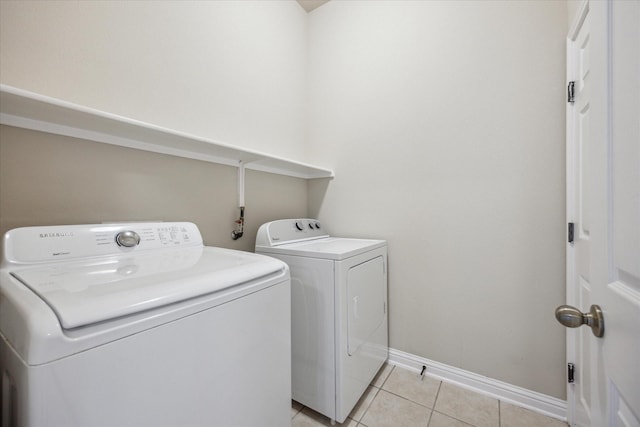 washroom with light tile patterned floors and washing machine and clothes dryer