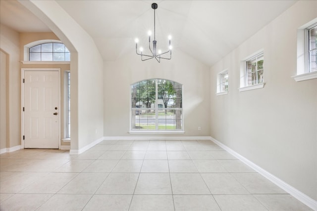 tiled foyer entrance with vaulted ceiling and a chandelier