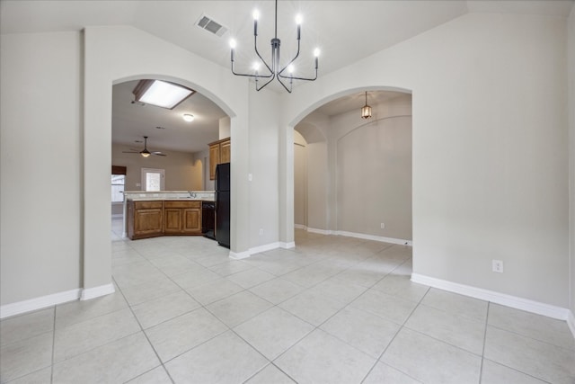 interior space with light tile patterned floors, ceiling fan with notable chandelier, lofted ceiling, and sink