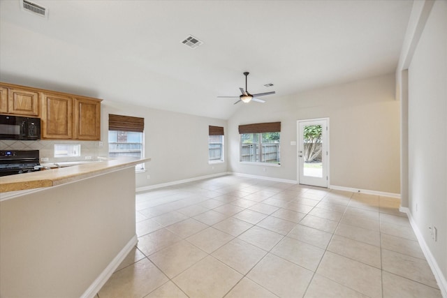 kitchen with black appliances, vaulted ceiling, ceiling fan, light tile patterned floors, and tasteful backsplash