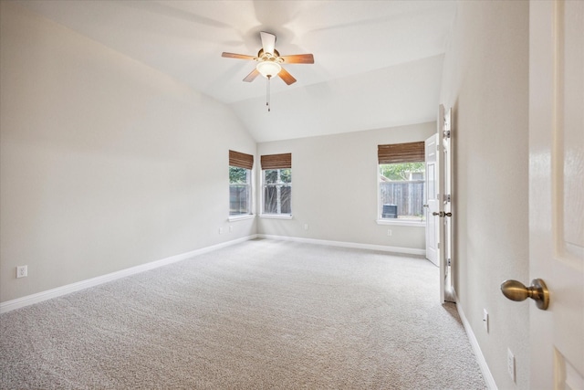 empty room featuring ceiling fan, lofted ceiling, and light carpet