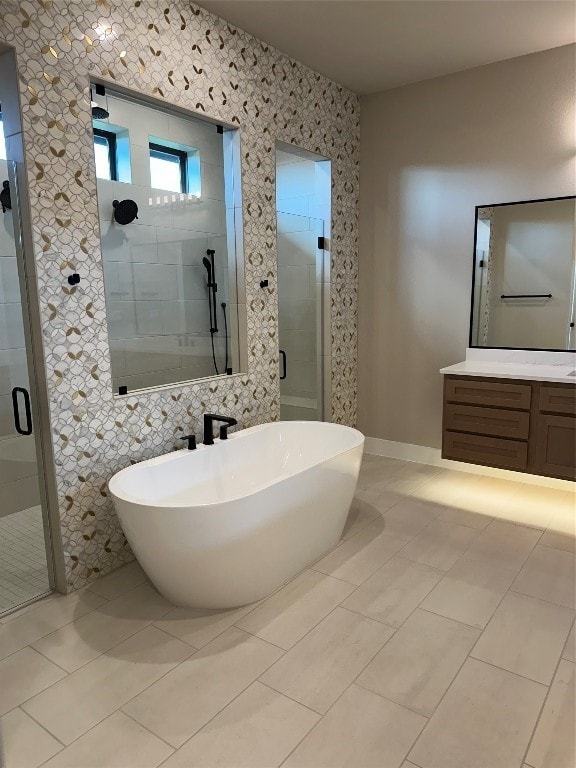 bathroom featuring tile walls, shower with separate bathtub, tile patterned floors, and vanity