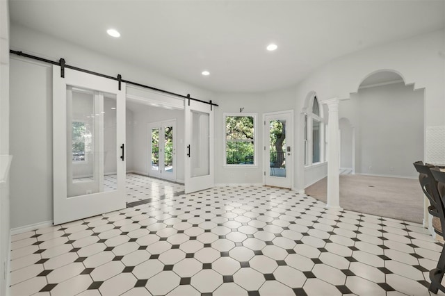 foyer with french doors, ornate columns, and a barn door