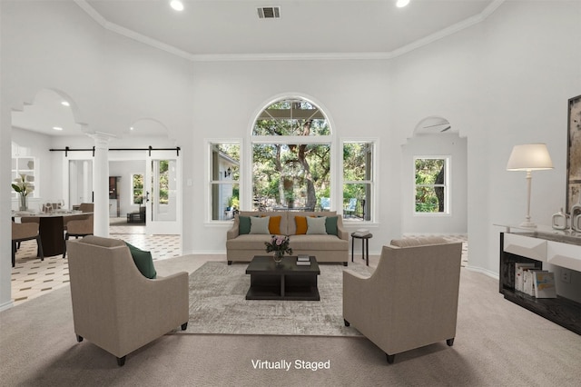 living room with crown molding, a barn door, and light carpet