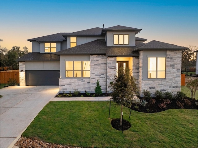 prairie-style house featuring a garage and a lawn