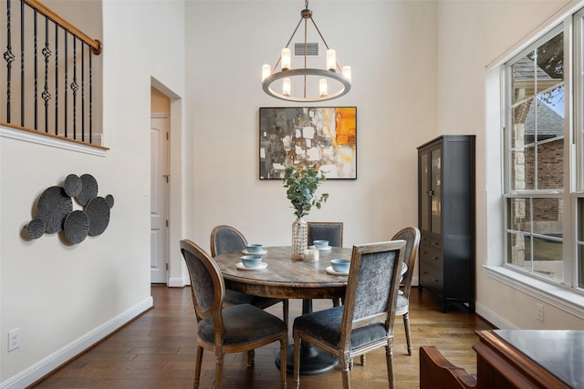 dining space featuring dark hardwood / wood-style floors and an inviting chandelier