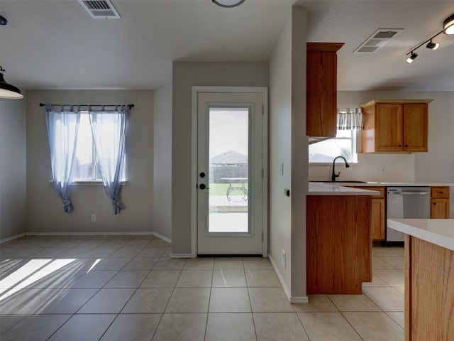 kitchen featuring light tile patterned floors, sink, a healthy amount of sunlight, and dishwasher