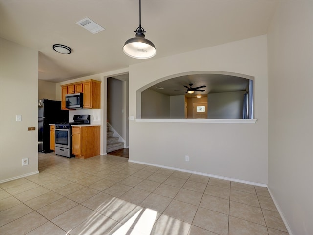 kitchen featuring light tile patterned flooring, appliances with stainless steel finishes, ceiling fan, and decorative light fixtures