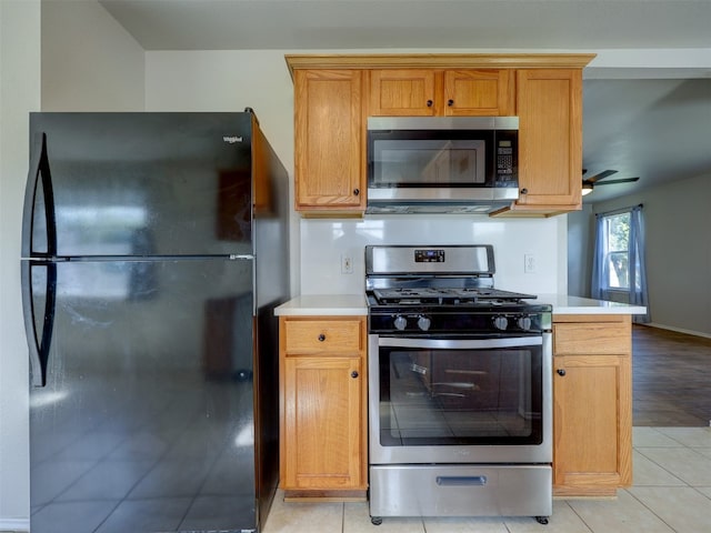 kitchen featuring appliances with stainless steel finishes, ceiling fan, and light tile patterned floors